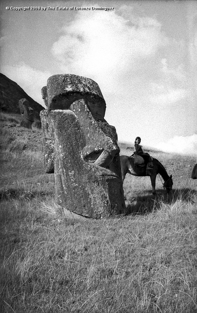 RRE_Hundido_10.jpg - Easter Island. 1960. Moai on the exterior slope of Rano Raraku. Identified by Lorenzo Dominguez as "The Sunken One." In the back, Isabel riding her horse.