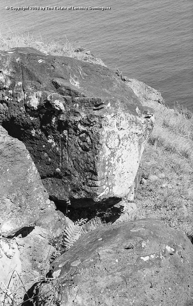 ORO_090.jpg - Easter Island. 1960. Orongo. Rock with a makemake petroglyph. Lorenzo Dominguez was stricken by the similitude between two plastic solutions: his own depiction of Death" over the surface of a black granite cube (see Lorenzo Dominguez. Catalog  P58 - 1949), and the one chosen by an anonymus Rapanui artist for this face of makemake, the "god of the big eyes," on two flat, angled planes of a rock.